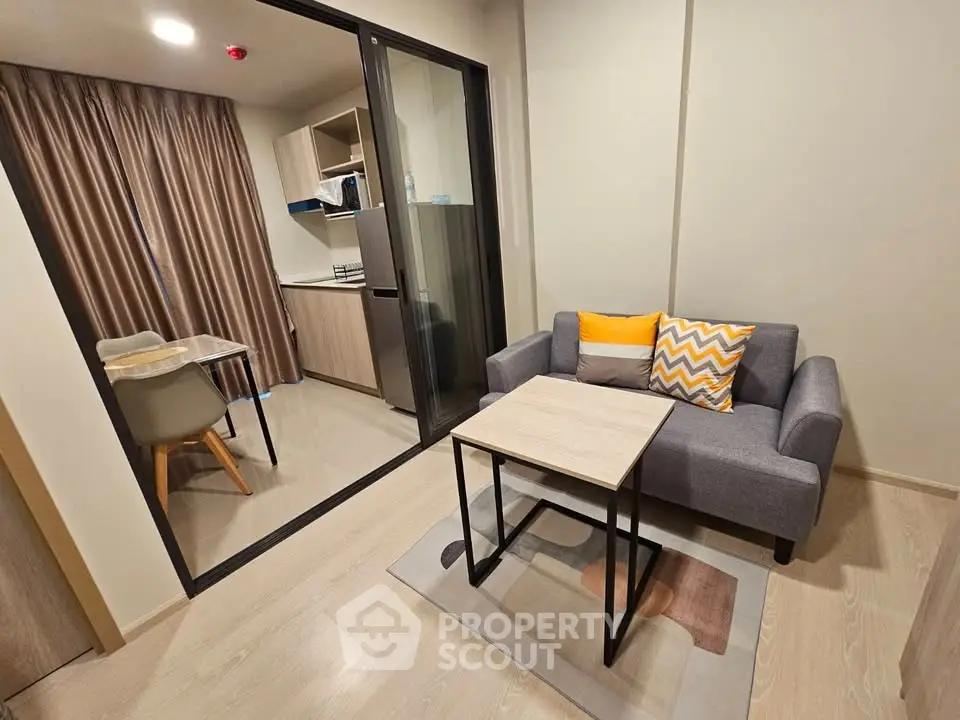 Modern living room with cozy sofa and open kitchen layout in stylish apartment.