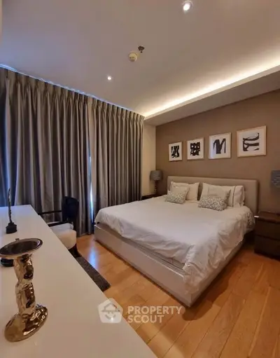 Luxurious bedroom with elegant decor and cozy ambiance, featuring a large bed and stylish artwork.