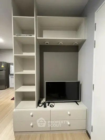 Modern living room with built-in shelving and TV unit, showcasing sleek design and functionality.