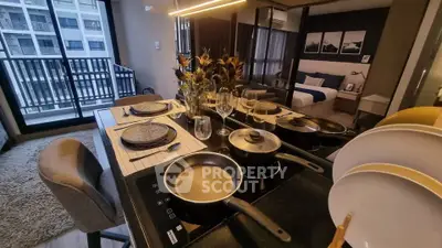 Modern kitchen with dining setup and view of stylish bedroom in open layout apartment.