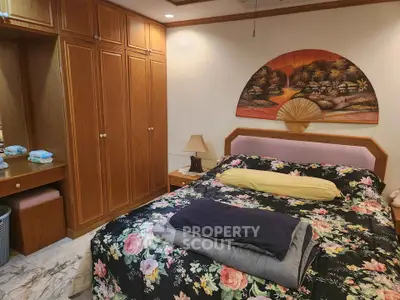 Cozy bedroom with floral bedding and wooden wardrobe