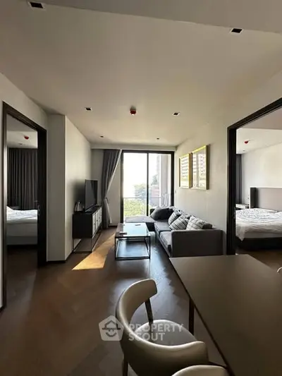 Modern living room with stylish decor and natural light, featuring a cozy sofa and elegant furnishings.