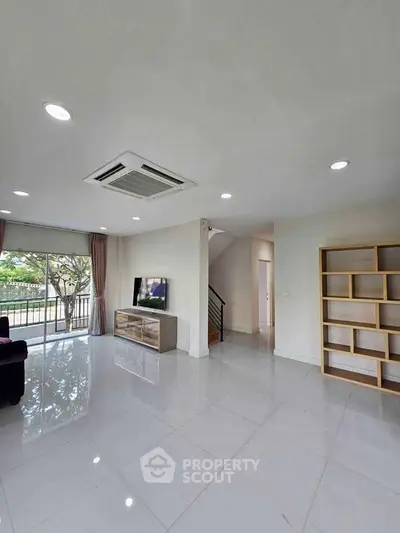 Spacious living room with modern design and large windows offering natural light.