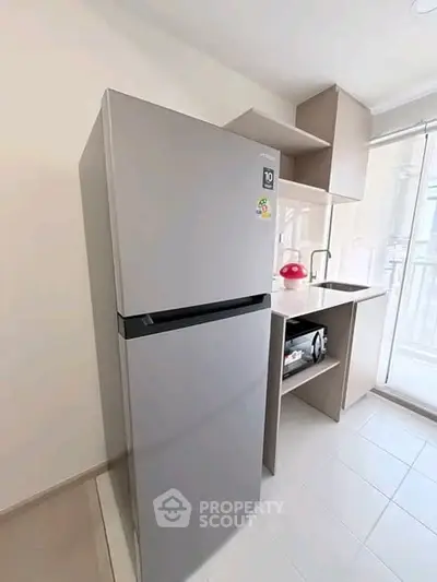 Modern kitchen with sleek fridge and compact design, perfect for urban living.