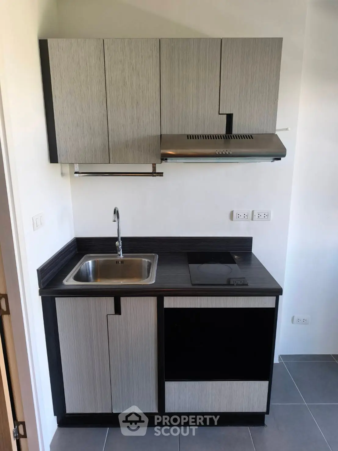 Modern compact kitchen with sleek cabinetry and built-in stovetop, perfect for urban living.