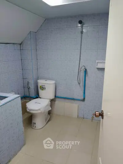 Compact bathroom with blue tiled walls and modern fixtures