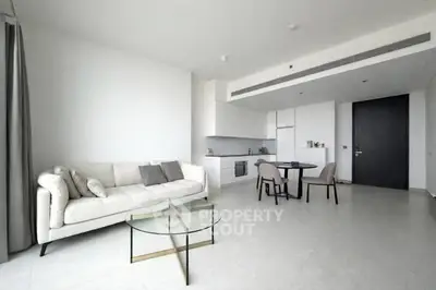 Modern open-plan living room with sleek kitchen and stylish furniture in a bright apartment.