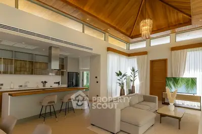 Luxurious open-plan living room with high wooden ceiling and modern kitchen bar.