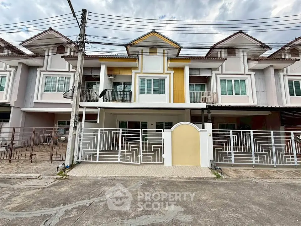 Charming townhouse with modern facade and gated entrance in a serene neighborhood.