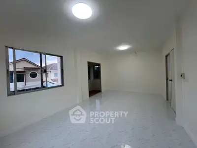 Spacious empty room with large windows and bright lighting, ideal for customization.