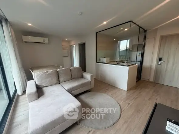 Modern open-plan living room with stylish kitchen and cozy sofa in a bright apartment.