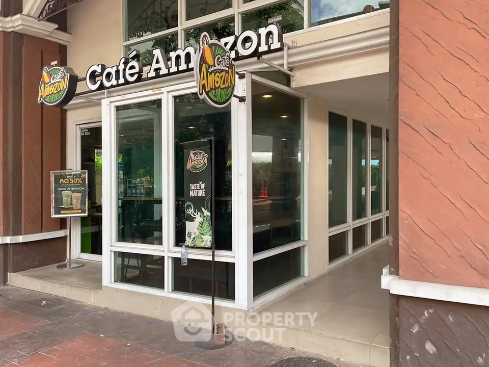 Charming cafe exterior with modern glass facade and inviting entrance, perfect for a cozy coffee break.