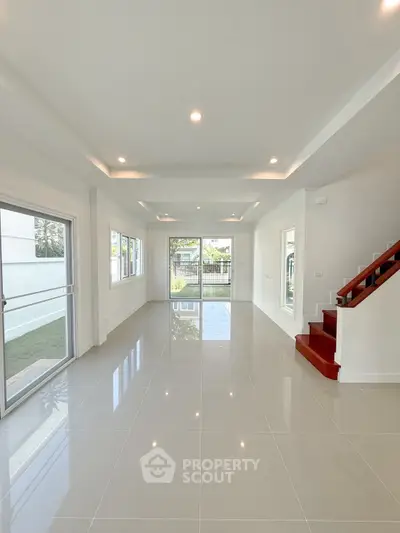 Spacious modern living room with large windows and garden view, perfect for family gatherings.