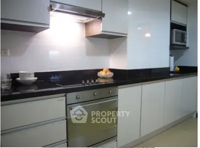 Modern kitchen with sleek cabinetry and built-in oven, perfect for culinary enthusiasts.