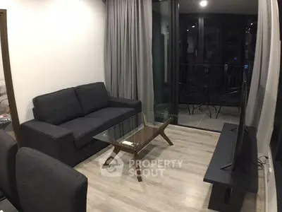 Modern living room with sleek furniture and balcony access, perfect for urban living.