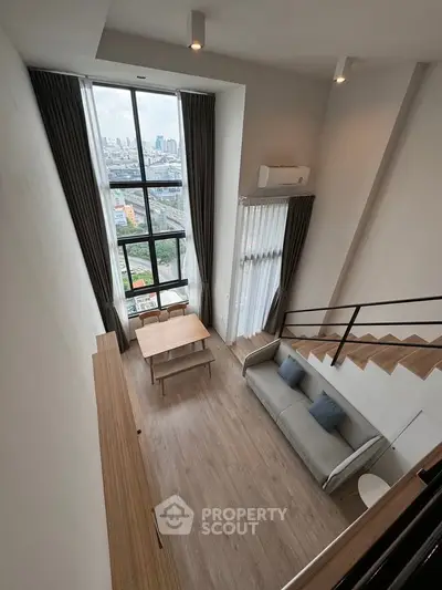 Stunning loft apartment with high ceilings and panoramic city views, featuring modern furnishings and elegant design.