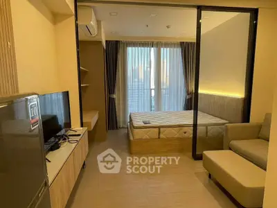 Modern studio apartment with cozy living area and bedroom, featuring large windows and stylish decor.