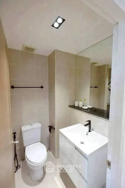 Modern bathroom with sleek fixtures and large mirror in a contemporary apartment.