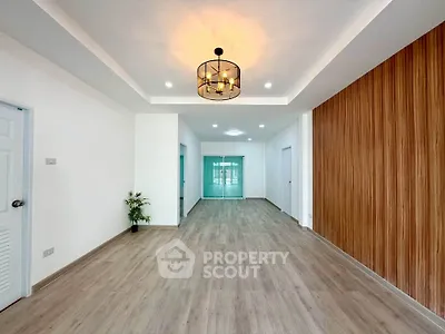 Spacious modern living room with elegant lighting and wood panel accent wall.