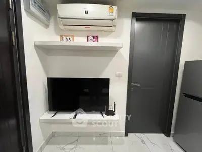 Modern living room with sleek TV setup and air conditioning in stylish apartment.