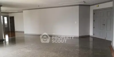 Spacious empty living room with polished floors and neutral walls, ready for customization.