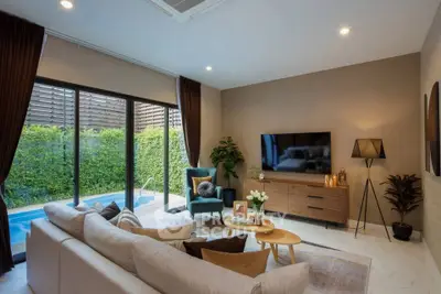 Luxurious living room with pool view, modern decor, and cozy seating area.