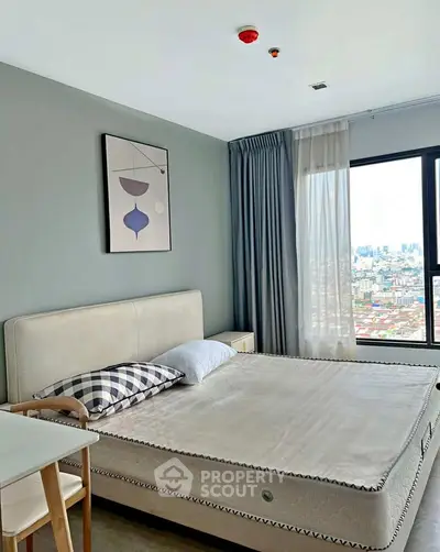 Modern bedroom with city view, featuring stylish decor and large window for natural light.