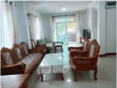 Spacious living room with elegant wooden furniture and large windows for natural light.