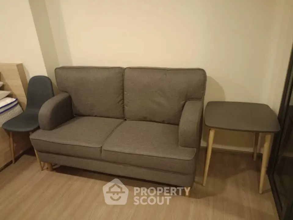 Cozy living room with modern gray sofa and stylish side table, perfect for relaxation.