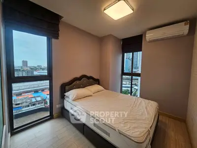 Modern bedroom with city view, featuring a comfortable bed and air conditioning.