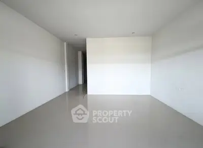Spacious empty room with white walls and tiled floor, perfect for customization.