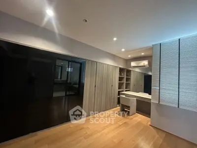 Spacious modern bedroom with sleek built-in closet and wooden flooring