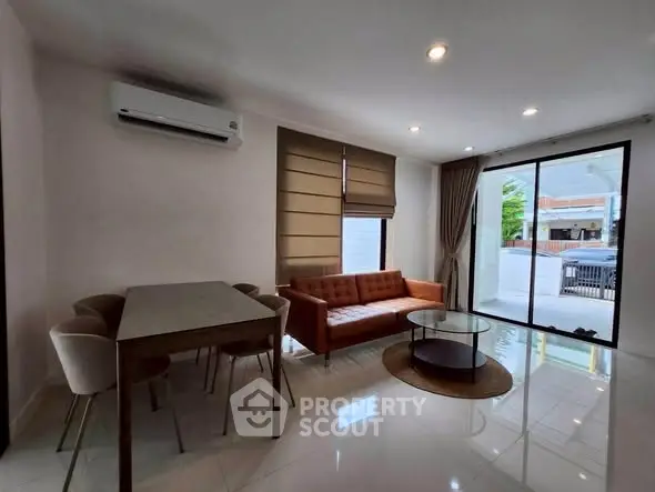 Modern living room with sleek furniture and large windows offering natural light.