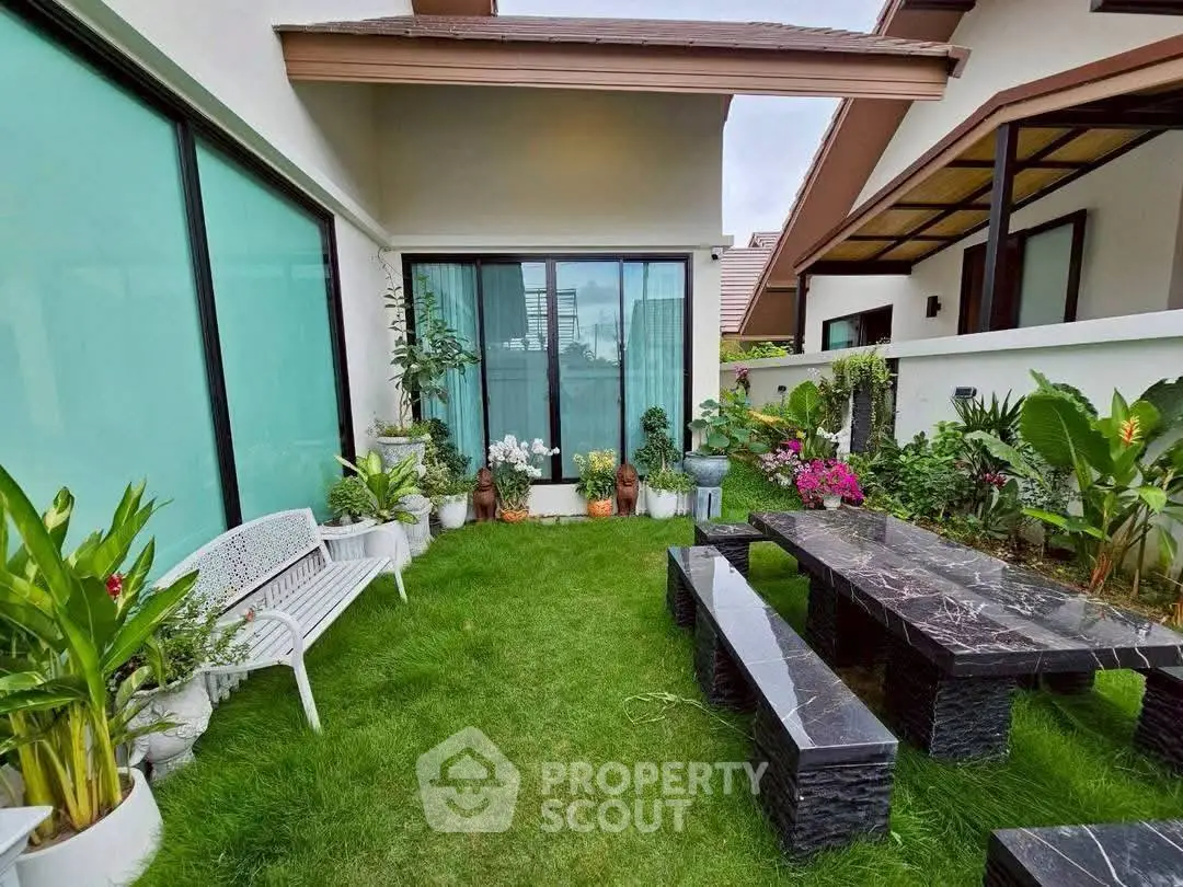 Charming garden view with elegant outdoor seating and lush greenery in a modern home setting.