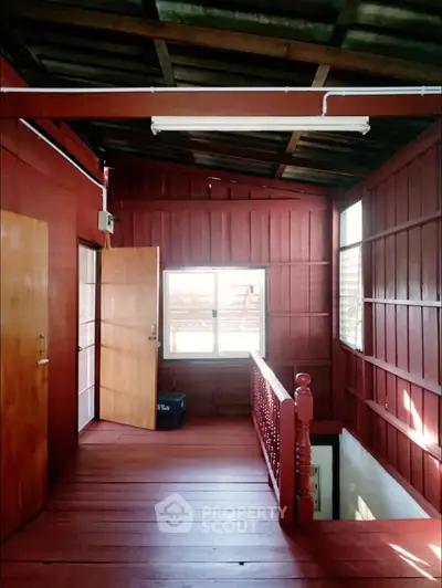 Charming rustic wooden interior with natural light and open stairway, perfect for cozy living.