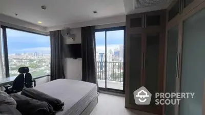 Modern bedroom with stunning city view and large windows in high-rise apartment.