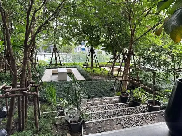 Lush garden with stone pathway and seating area, perfect for relaxation.