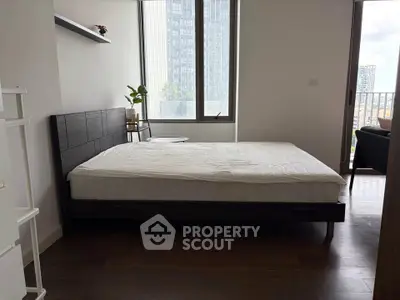 Modern bedroom with large windows and city view, featuring a sleek bed and minimalist decor.