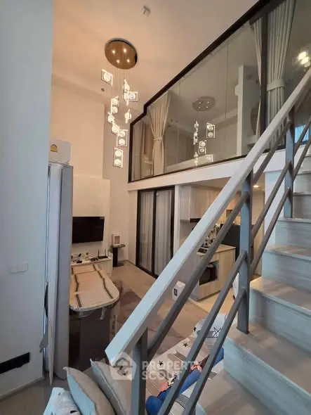 Modern loft apartment with stylish staircase and elegant lighting, featuring a cozy living area and open kitchen.