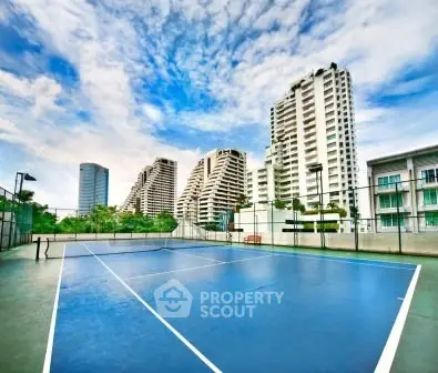 Stunning tennis court with modern high-rise buildings in the background, perfect for urban living.