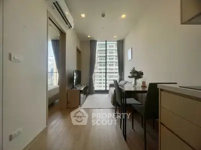 Modern apartment interior with open layout and city view, featuring stylish furniture and natural light.
