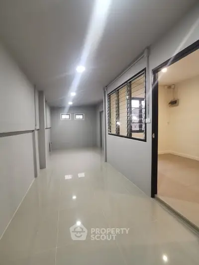 Spacious hallway with modern tile flooring and ample natural light