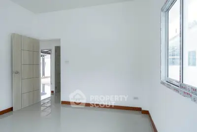 Spacious empty room with large window and modern door
