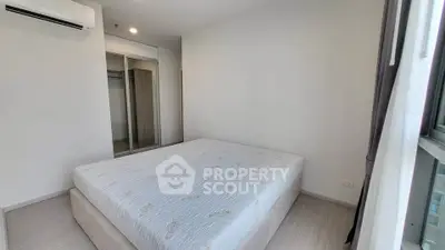 Spacious bedroom with large window and mirrored closet in modern apartment