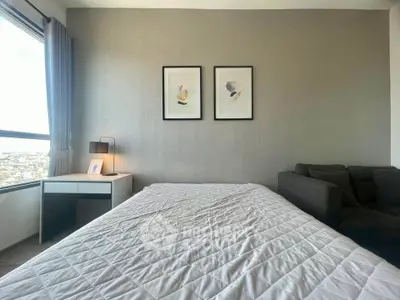 Modern bedroom with stylish decor and large window offering natural light.