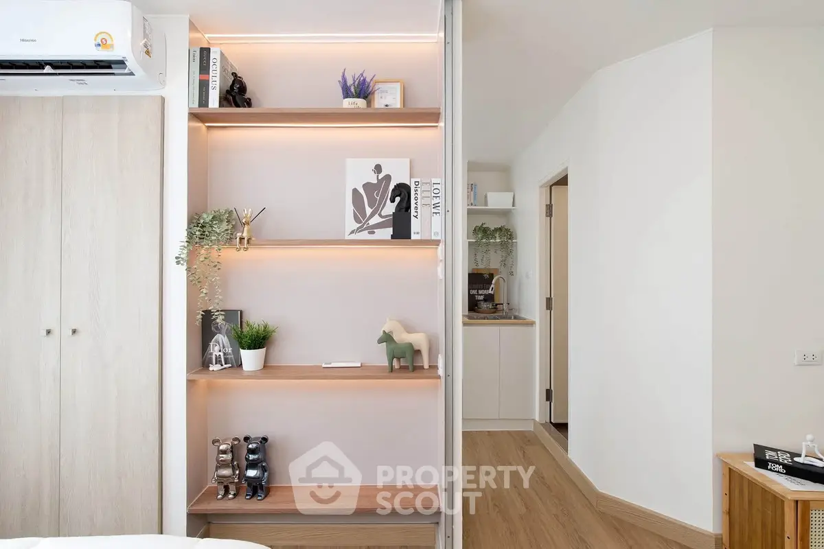 Modern living room with stylish shelving and wooden flooring, featuring elegant decor and natural light.