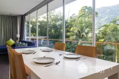 Modern dining area with large windows and lush garden view