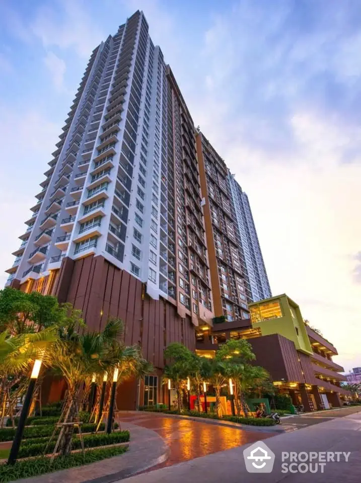 Stunning high-rise building with modern architecture and lush landscaping at sunset.