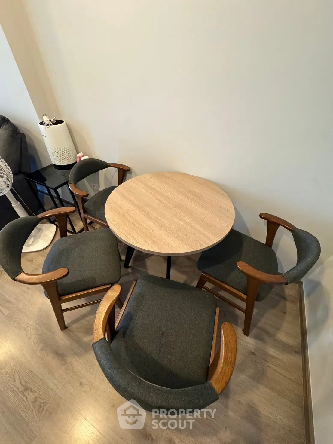 Cozy dining area with round wooden table and stylish chairs, perfect for intimate gatherings.