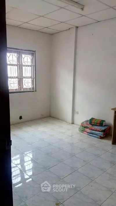 Spacious unfurnished room with tiled floor and natural light, ideal for customization.